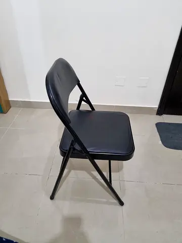 Black metal folding chair with padded seat and back