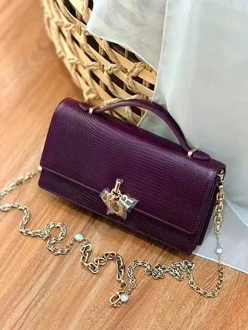 Show a dark purple lizard textured handbag