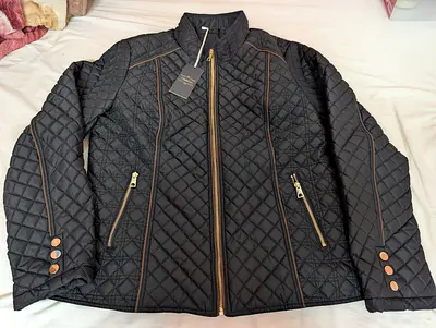 Black diamond-quilted lightweight jacket featuring elegant brown contrast piping and gold-toned zipp