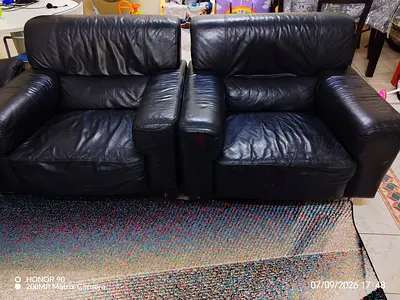 Pair of used black leather 2-seater sofas — sturdy, some wear