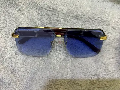 Men's rectangular rimless blue-lens sunglasses with gold accents