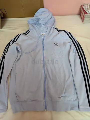 That's a light blue Adidas Originals Female-M hoodie featuring signature black three-stripe detailin
