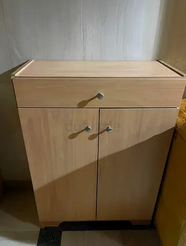Small light-wood storage cabinet with drawer and double doors