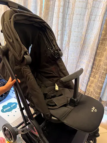 Used black pram stroller in good condition - lightweight and foldable travel friendly