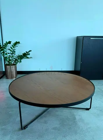 Round low coffee table with wood top and black metal frame