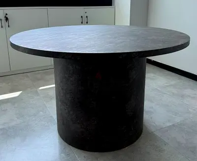 Round black dining table with cylindrical base - solid modern design