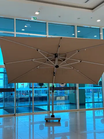 Large beige outdoor patio umbrella with metal base - excellent condition