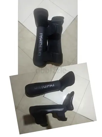 Pair of black shin guards with foot protection - used