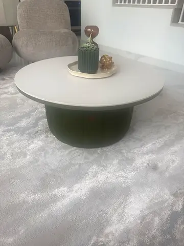 Modern round coffee table with white top and olive base