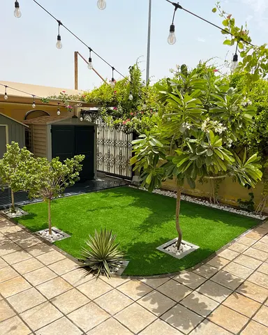 Artificial grass lawn with planted trees