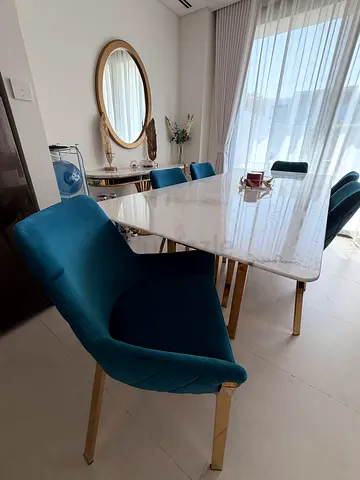 Marble-top dining table with 6 teal velvet chairs