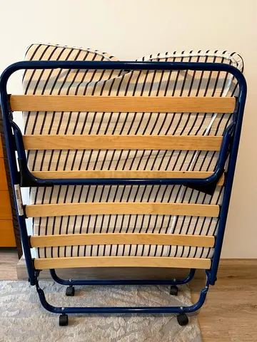 Foldable single guest bed with wooden slats and wheels — good condition