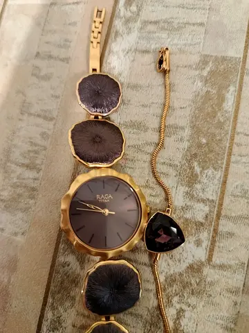 Titan Raga women's gold-tone bracelet watch with decorative work.