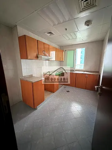 شقة واسعة للإيجار في "أورينت تاور" (Orient Tower)، تتكون من غرفة نوم واحدة وصالة (1 BHK)، مع موقف سيارات وحمامين وشرفة (بإطلالة مفتوحة على الحديقة)، ب