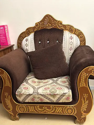 Single ornate upholstered armchair with carved wooden frame - brown