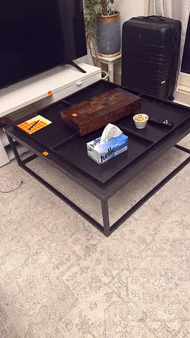 Black metal frame coffee table with wooden top with 4 separate sections/the One brand
