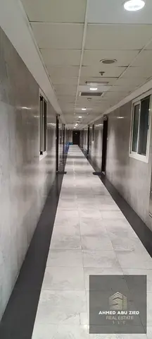 Spacious 2-bedroom apartment in City Towers Ajman with 2 bathrooms and a closed kitchen with appliances, including washing machine, fridge, and TV.
