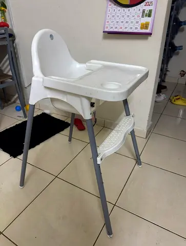 Simple white baby high chair with tray and footrest
