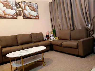 L-shaped brown fabric sofa with coffee table and rug - good condition