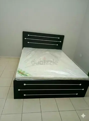 Black wooden double bed frame with mattress