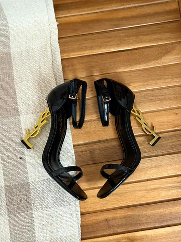 Black patent heels with gold logo heel, size not specified
