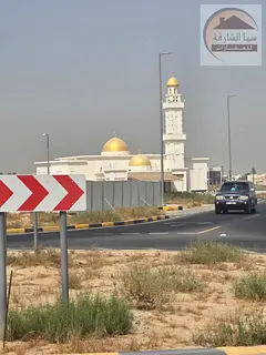 Residential corner plot for sale in Sharjah, Al Hooshi area, on a 24-meter street and an 18-meter st