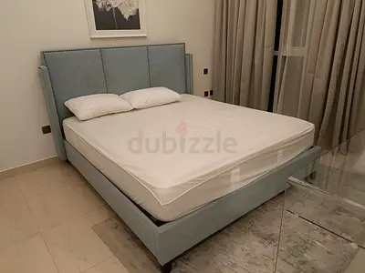 Light blue upholstered double bed frame with mattress