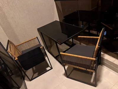 Outdoor wicker-style pair of chairs with glass-top side table