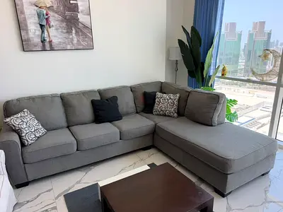 Comfortable L-shaped grey fabric sofa with chaise — good condition