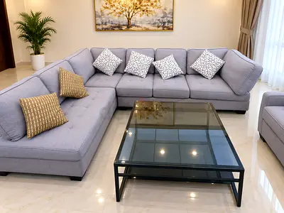 Light grey L-shaped sectional sofa with glass coffee table - excellent condition