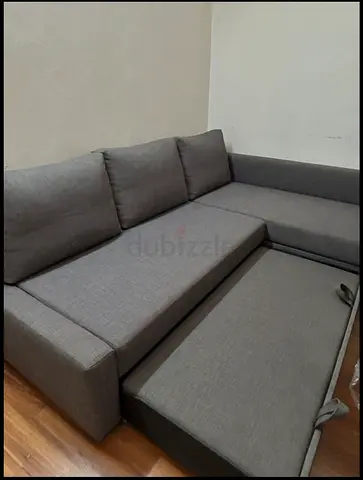 Grey L-shaped sofa with pull-out bed - good condition