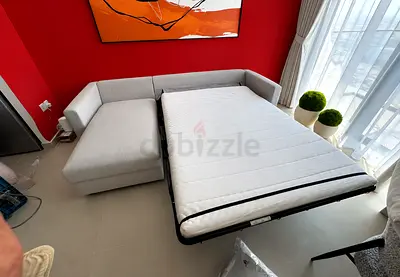 Light grey L-shaped sofa bed with pull-out bed - good condition