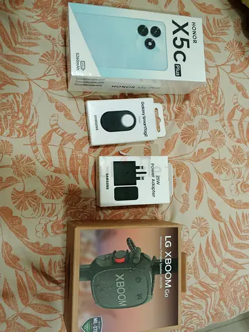 Honor X5C Plus with Samsung charger, power adapter and LG XBoom Go speaker