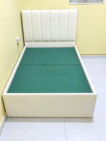 Single white upholstered bed with padded headboard
