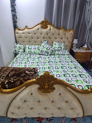 Ornate tufted king-size bed with gold trim