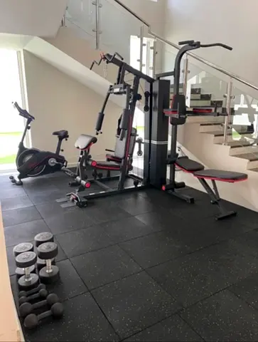 Home multi-gym station with dumbbells and exercise bike