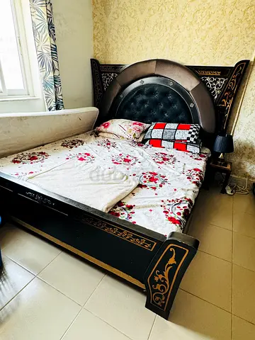 Queen size carved wooden bed with upholstered headboard