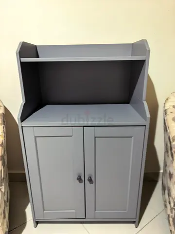 Compact grey storage cabinet with open shelf and cupboard