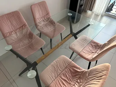 Modern glass dining table with four pink velvet chairs