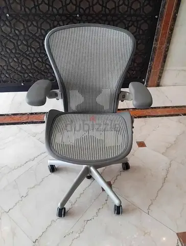 Herman Miller Ergonomic grey mesh office chair with adjustable armrests and wheels
