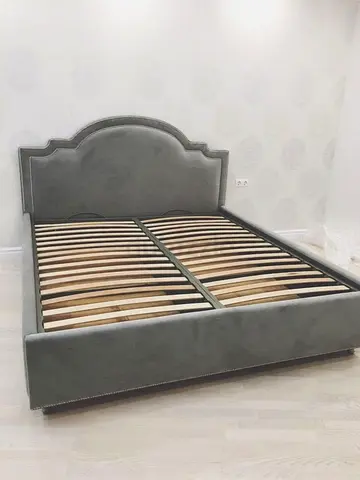 Grey upholstered double bed frame with decorative headboard