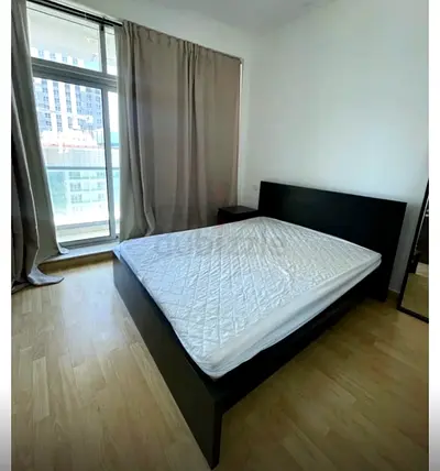 IKEA bed with mattress and side table