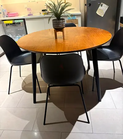Round wooden dining table with 4 black chairs
