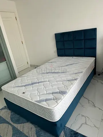 Blue upholstered bed frame with mattress - excellent condition.