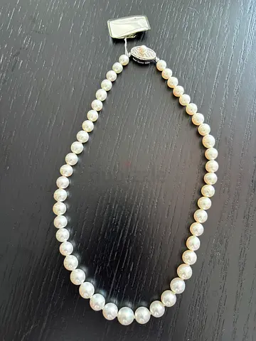 Classic single-strand pearl necklace with decorative clasp , made in Japan.