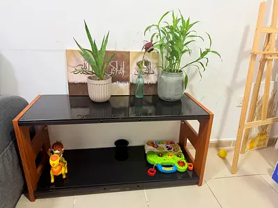 Small modern two-tier coffee/side table with black glass top and wooden frame