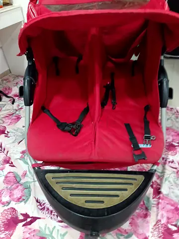 Red side-by-side double stroller in good condition