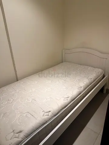 Single white wooden bed frame with mattress