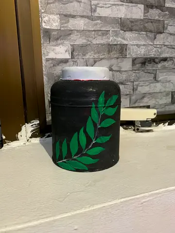 Hand-painted black pot with green leaf design by myself