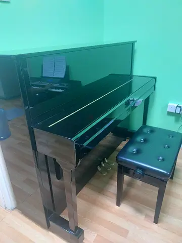 Upright piano in good condition with matching bench.